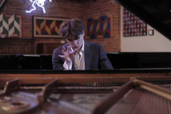 Ellis Arey at the piano, poised ready to play