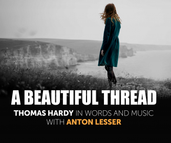 Woman with red hair wearing a blue coat is standing on edge of cliff looking across to the sea