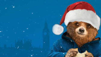 Paddington Bear eating a marmalade sandwich with a santa hat on