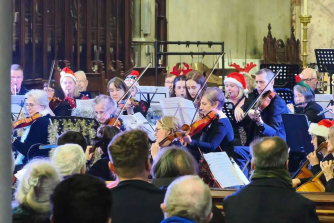 People in black playing instruments in a church