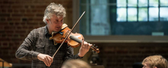 Peter Hanson plays the violin during rehearsals