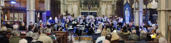 Members of Monmouth Concert Orchestra playing their instruments dressed in black