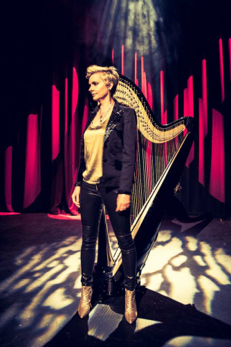Catrin Finch standing in front of harp