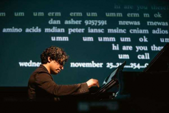 Zubin Kanga seated at the piano, with text projected onto a screen behind him.