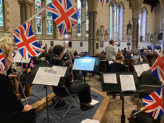 Members of Monmouth Concert Orchestra playing their instruments dressed in black