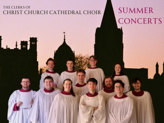 The clerks of christ church cathedral choir in front of a silhouetted skyline of christ church, oxford