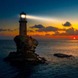 A lighthouse shining at sunset.